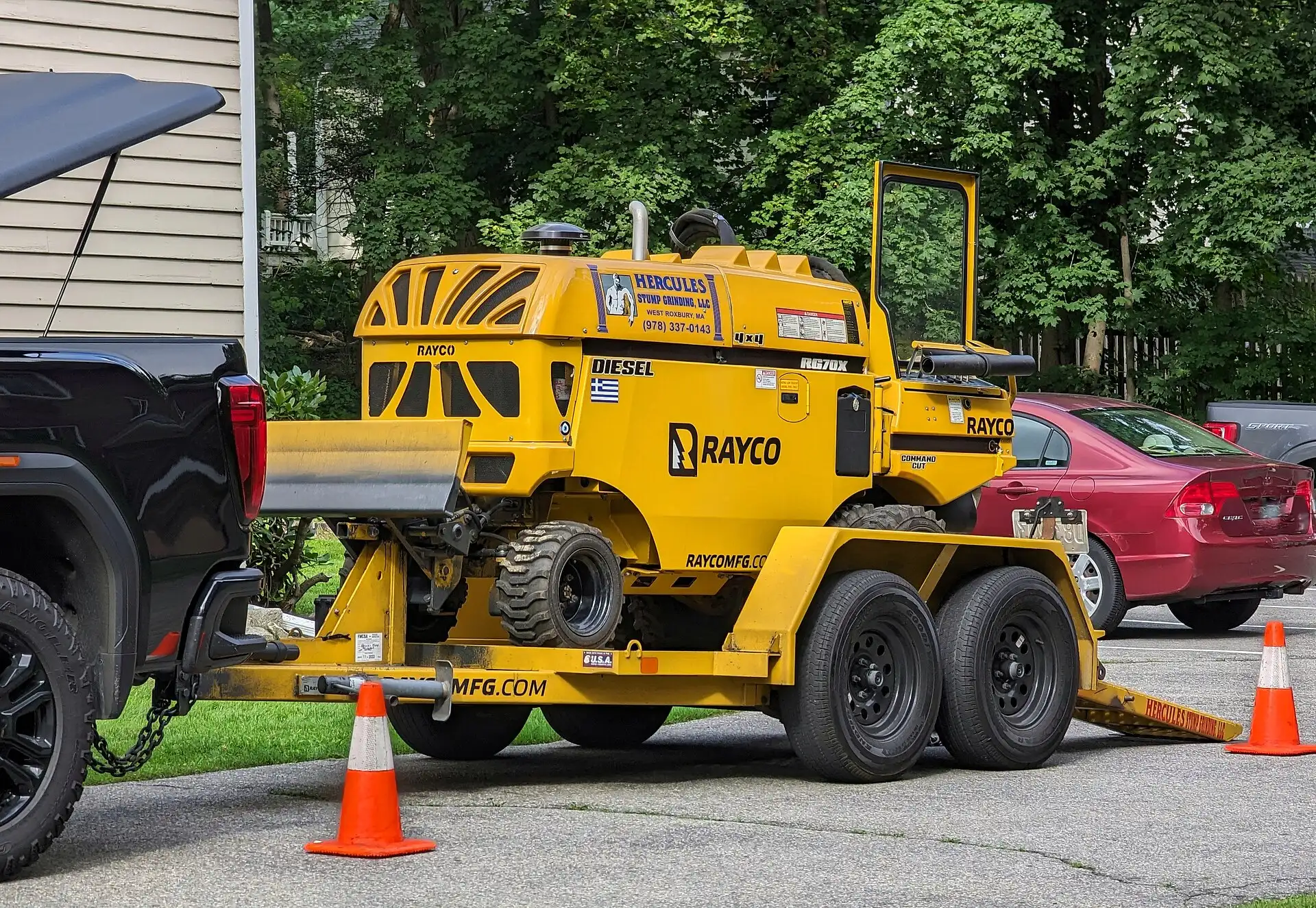 Stump grinder and work truck with safety cones at the curb